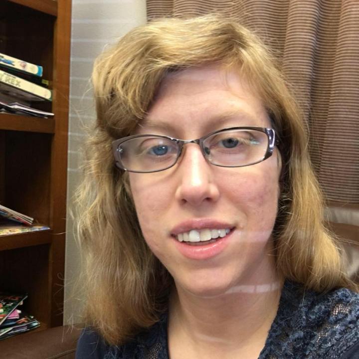 A head shot of Amanda shows her smiling. She wears glasses.