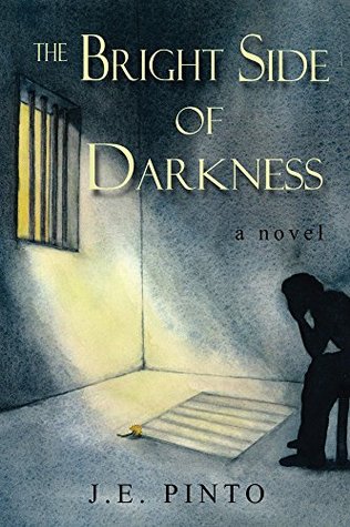 Image shows the cover of the The Bright Side of Darkness by J.E. Pinto.The cover shows a figure in silhouette sitting with their head in their hands inside a room with a barred window. 